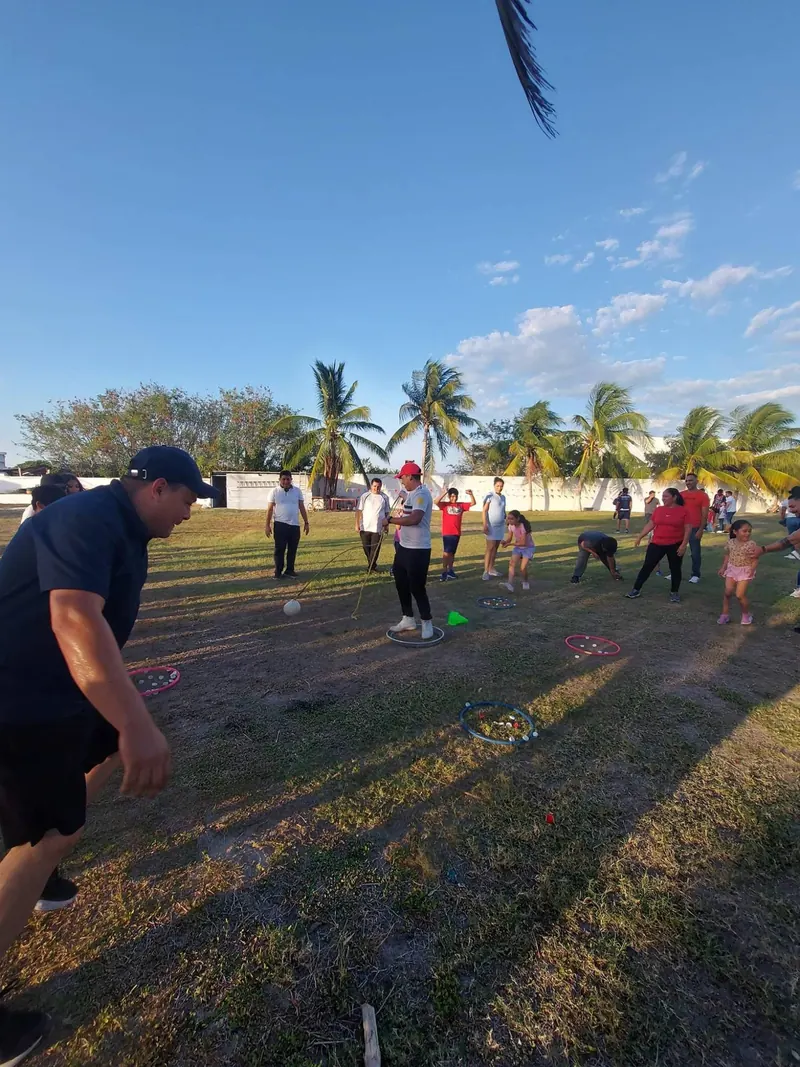Papás, maestros y alumnos participan en juegos al aire libre en el patio